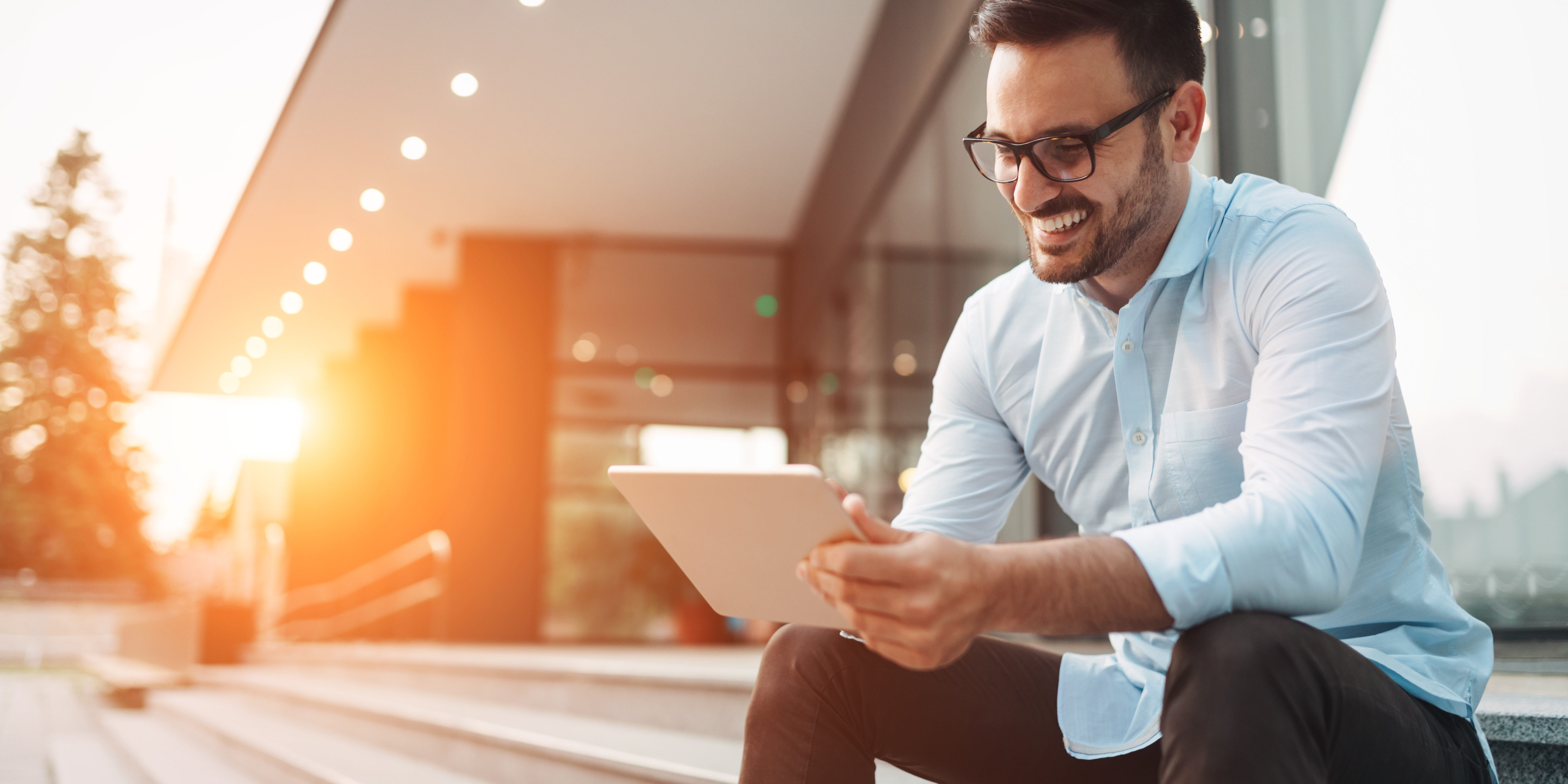 Portrait of businessman in glasses holding tablet