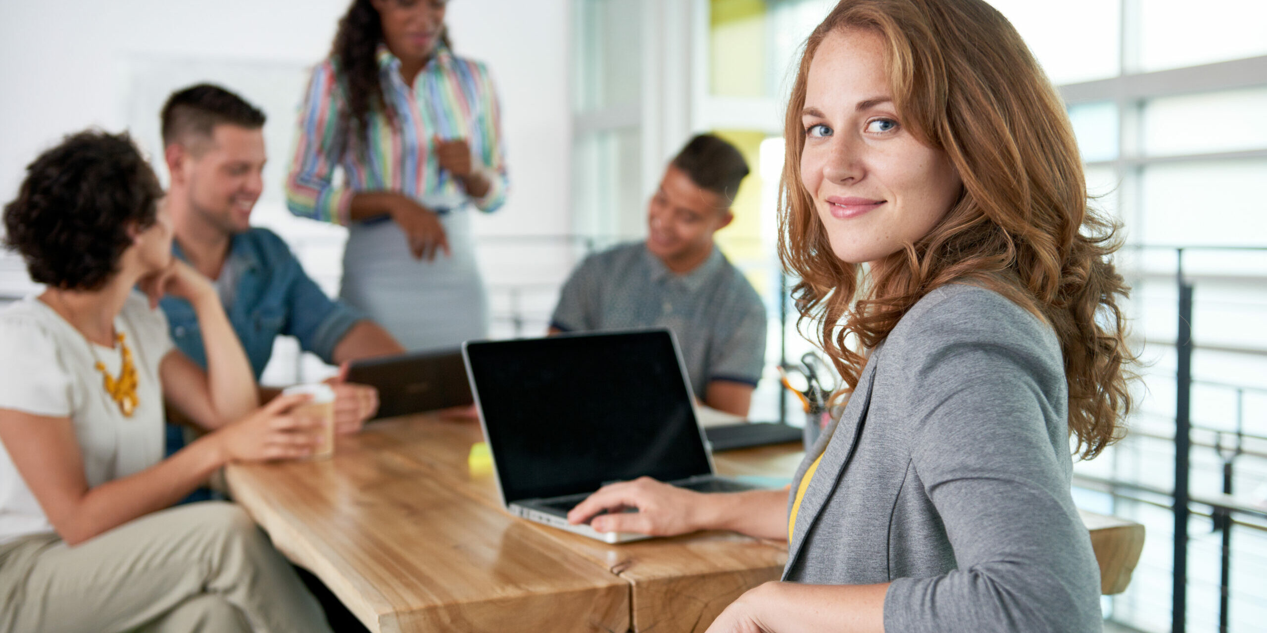 Image of a succesful casual business woman using laptop during meeting assurance-vie les sables d'olonne
